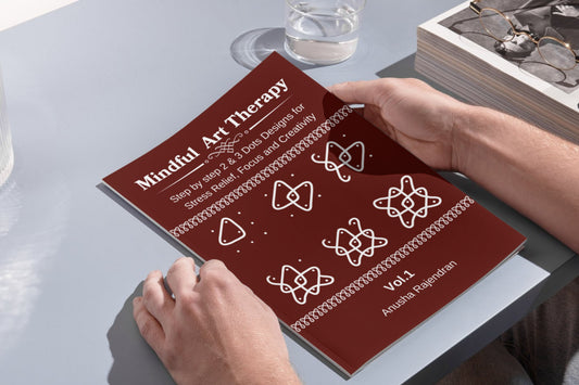 Mindful Art Therapy' on a table with a person's hands holding it.